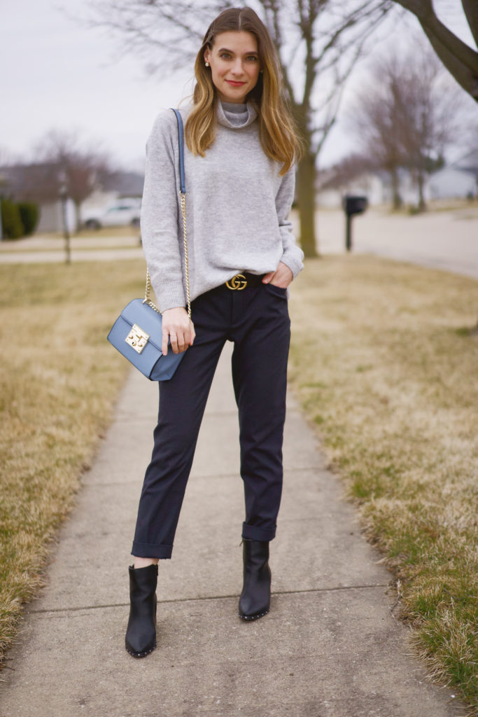 Women's work wear outfit with navy dress pants and a gray turtleneck sweater 