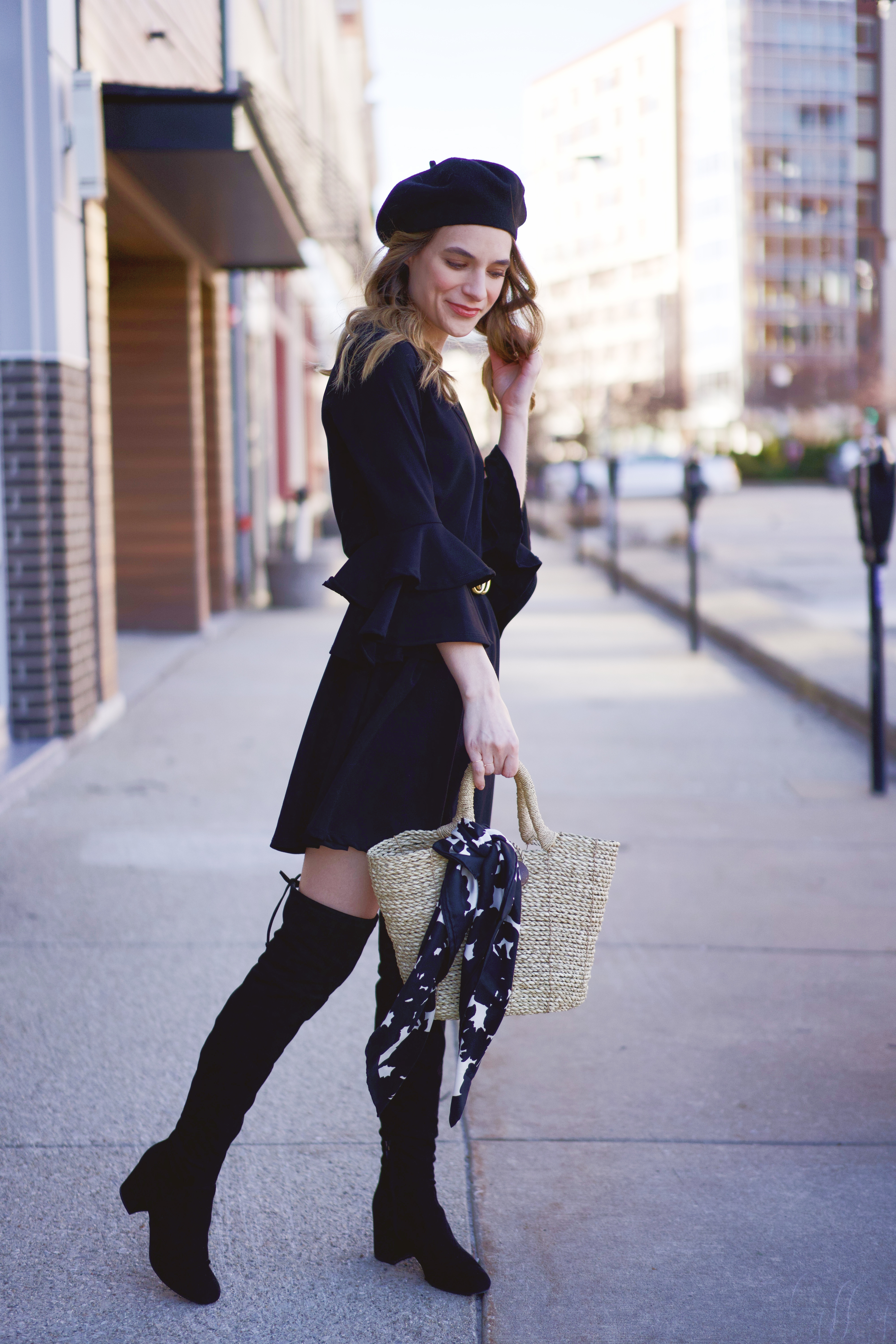 An all black outfit with a straw bag 