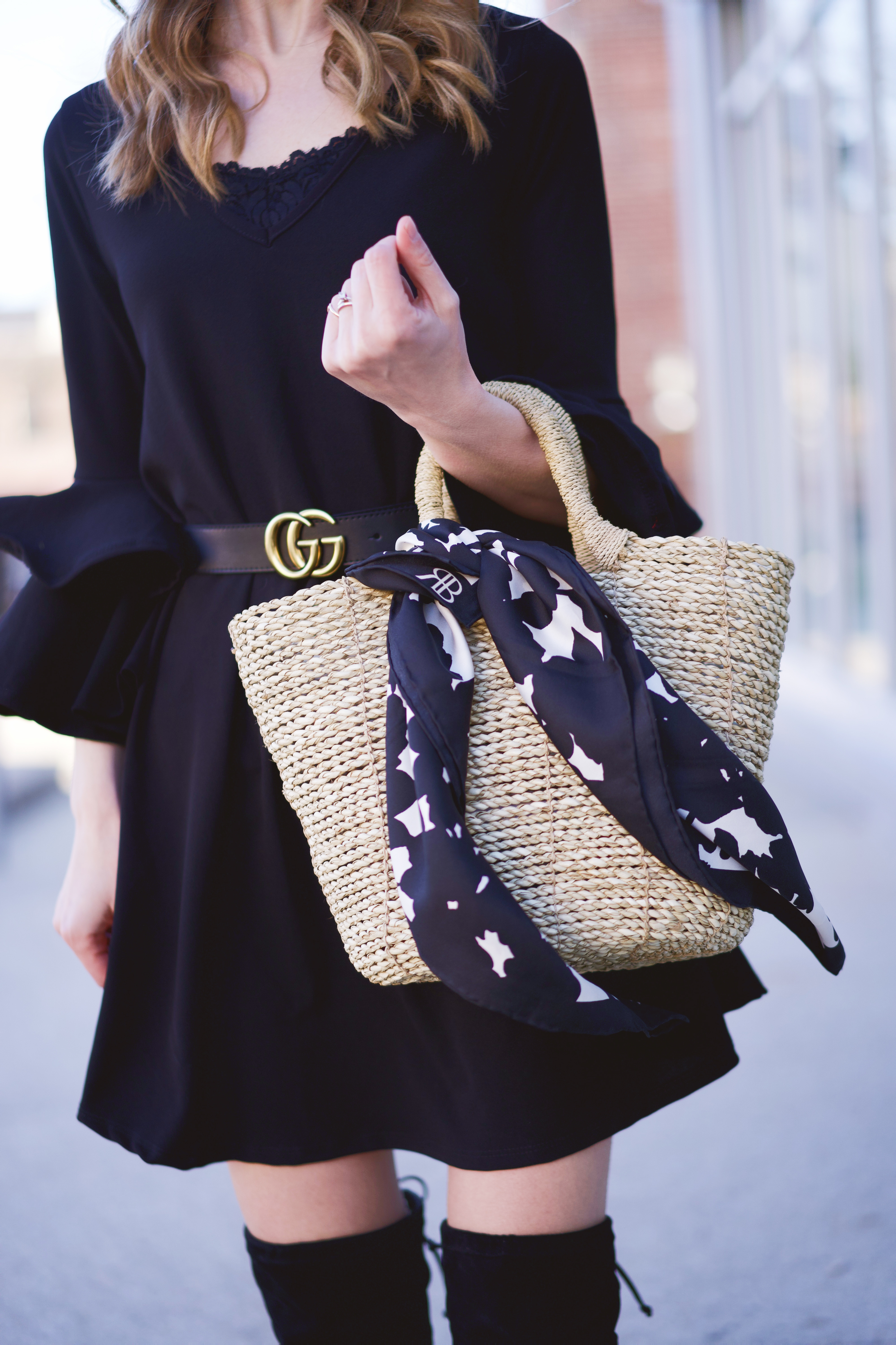 A black and white Banana Republic scarf tied onto a straw bag