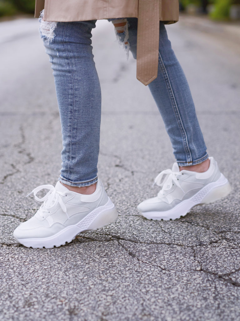 Close up of women's white sneakers and jeans