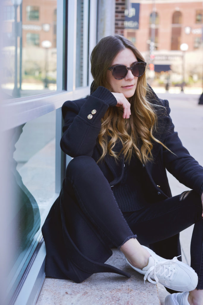 Woman wearing all black sitting on the curb